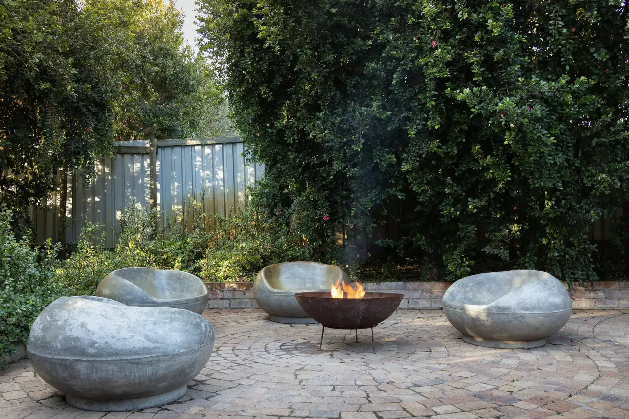 Stone seats around a fire bowl on brick paving